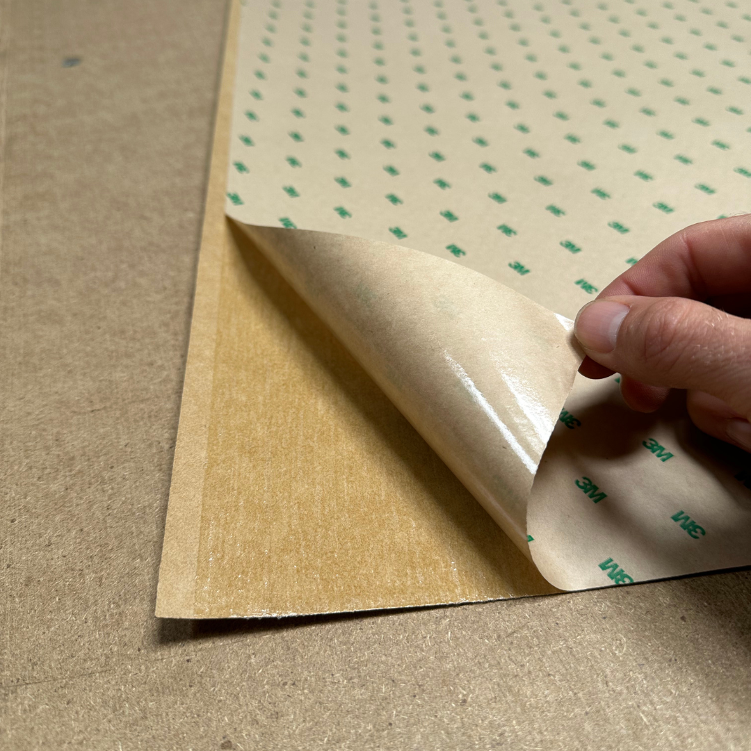 someone peeling back a peel and stick wood veneer sheet